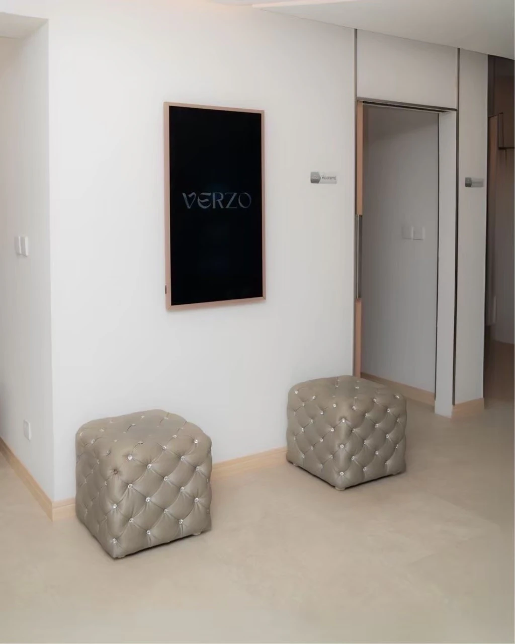 VERZO wall sign beside the hallway and tufted stools at the Ekkamai clinic