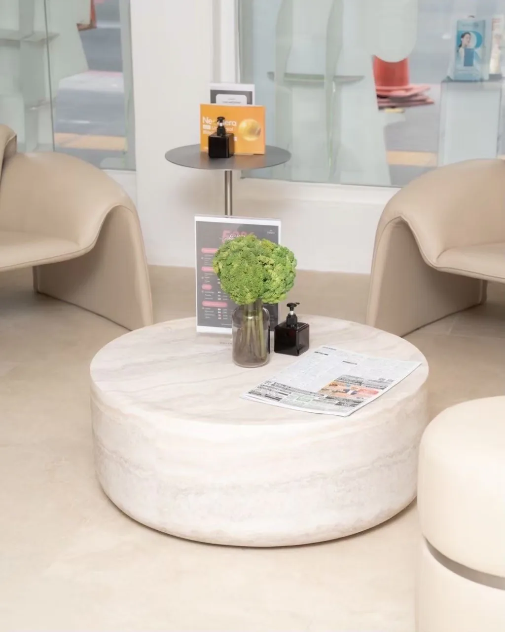Cream lounge chairs and a round marble table inside VERZO CLINIC Ekkamai